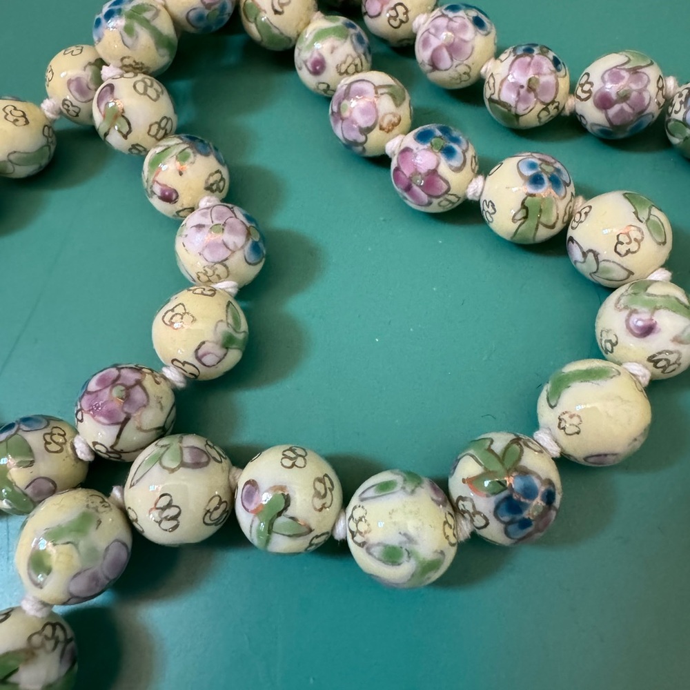 16 inch strand of cloisonné hand, knotted beads, floral design in purple & blue